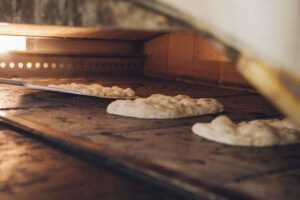 Three pinsa crusts in an oven.